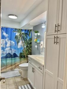 ホノルルにあるWaikiki Condo 2 Bedrooms 2 Bathrooms with 1 free parking spaceのバスルーム(トイレ、ヤシの木のシャワーカーテン付)
