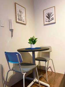 a table with two chairs and a plant on it at Air Residences Makati - fully furnished condo with skyline views! in Manila