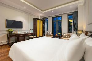 - une chambre avec un grand lit blanc et un bureau dans l'établissement Salute Premium Hotel & Spa, à Hanoï