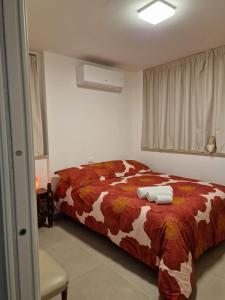 Dimora Deva في بيسكارا: غرفة نوم مع سرير وبطانية بنية وبيضاء