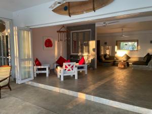 a living room with red and white chairs and a couch at Good Vibes Villas in Unawatuna