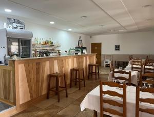 ein Restaurant mit einer Bar mit Tischen und Stühlen in der Unterkunft Lou Castellas in Eyguières
