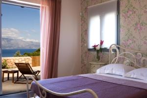 a bedroom with a bed and a window with a view at Elixrison Villas - Sea view Villa near Nidri in Nikiana