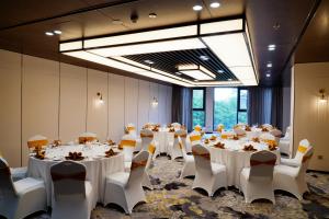 a conference room with white tables and chairs at The Five Residences Hanoi in Hanoi