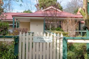 una staccionata bianca di fronte a una casa di Wrenfield Cottages a Marysville