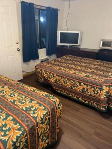 a hotel room with two beds and a flat screen tv at Johnston's Motel in Garberville