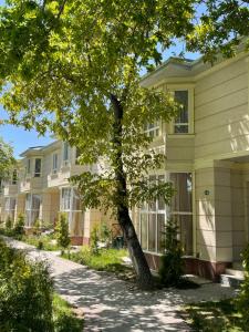 a row of houses with a tree in front at Raduga West 'Azure' Apartment in Koshkolʼ