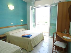 a hotel room with two beds and a window at Hotel Garden in Cervia