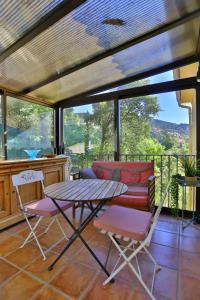 eine abgeschirmte Veranda mit einem Tisch und Stühlen in der Unterkunft Lantana luxury property in Bormes-les-Mimosas