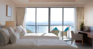a hotel room with two beds and a desk and a window at The Westin Siray Bay Resort & Spa, Phuket in Phuket