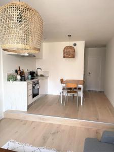a kitchen and dining room with a table and chairs at Le Simone: Appartement de charme coeur de village, 2 chambres in Villard-de-Lans