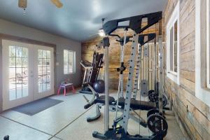een fitnessruimte met loopbanden in een kamer met een bakstenen muur bij South Valley Retreat in Avondale