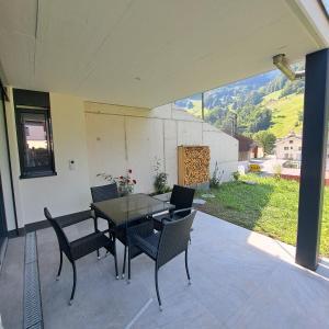 a table and chairs on a patio with a view at Ferienwohnung Muota in Muotathal