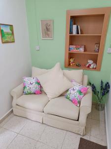 un sofá blanco con almohadas en la sala de estar en The Grapevine Guest House, en Pafos