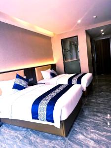 a row of three beds in a hotel room at 东方酒店 in Sihanoukville