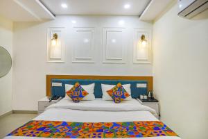 a bedroom with a large bed with colorful pillows at FabHotel Cosmos in Allahābād