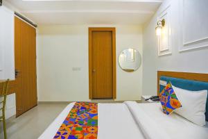 a bedroom with a bed with a colorful blanket at FabHotel Cosmos in Allahābād