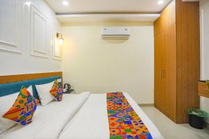 a bedroom with a bed with a colorful quilt on it at FabHotel Cosmos in Allahābād