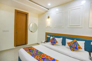 a bedroom with a large bed with a blue headboard at FabHotel Cosmos in Allahābād