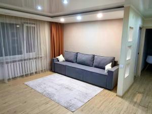 ein Wohnzimmer mit einem blauen Sofa in einem Zimmer in der Unterkunft Yanko in Kökschetau