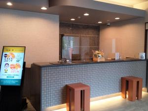 a restaurant counter with two stools and a sign at Hotel Route-Inn Tsu Ekiminami -Kokudo23gou- in Tsu