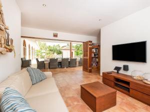 a living room with a white couch and a flat screen tv at Holiday villa at Jan Thielstrand in Willemstad in Jan Thiel