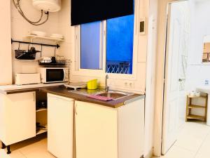 a kitchen with a sink and a microwave at Cheap Studios Malaga Center in Málaga
