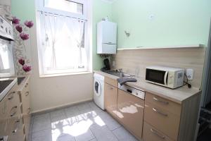 a small kitchen with a sink and a microwave at Chic Apartment with Balcony in Wuppertal +7 photos