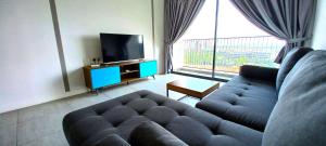 a living room with a couch and a flat screen tv at Bell Suites by Salaam Suites, Sepang in Sepang