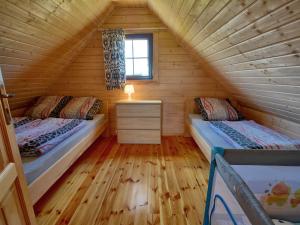 a bedroom with two beds in a wooden cabin at Nice holiday home located 800 m from the sea in Mielenko