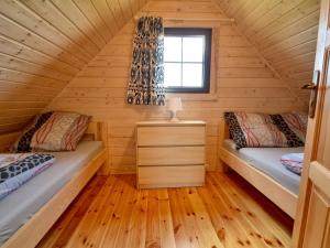 two beds in a log cabin with a window at Nice holiday home located 800 m from the sea in Mielenko