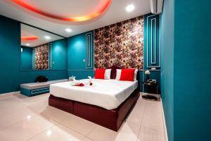 a bedroom with a large bed and blue walls at Crystal Hotel โรงแรมคริสตัล in Ban Nong Wa
