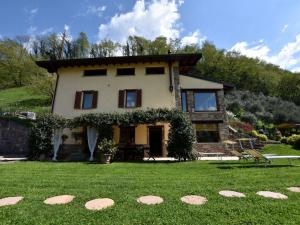 a house with a green lawn in front of it at Villa in Pisogne with pool garden and lake view in Pisogne