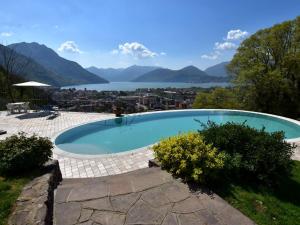 a swimming pool with a view of a lake and mountains at Villa in Pisogne with pool garden and lake view in Pisogne