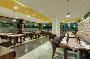 une salle à manger avec des tables et des chaises en bois dans l'établissement Hotel Balaji Central, à Ratlām