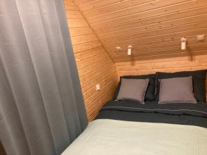 een slaapkamer met een bed in een houten kamer bij Domek nad rzeką in Wierzchlas