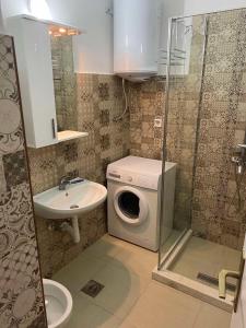 a bathroom with a washing machine and a sink at Linden apartment in Pluzine