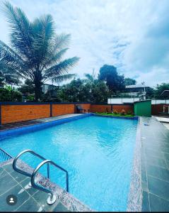 a large swimming pool with blue water in a building at SKY BLUE HOMESTAY with POOL in Vythiri