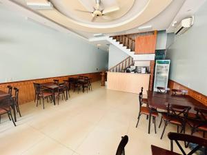 a dining room with tables and chairs and a ceiling at Majestic Hostel - Tour & Motorbike Rental in Ha Giang