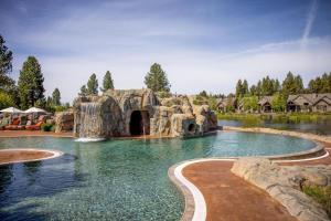 a swimming pool with a waterfall in a resort at Dancing Rock "Grandview Lodge" (Caldera Springs) in Sunriver