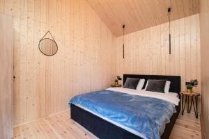 1 dormitorio con 1 cama en una pared de madera en Stodoły Słona Zatoka, en Władysławowo