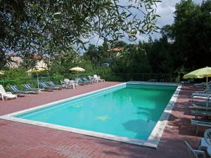 einen Pool mit Stühlen, Tischen und Sonnenschirmen in der Unterkunft Holiday Home in Paciano with Swimming Pool Terrace Billiards in Paciano