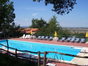 una piscina con tumbonas y sombrillas en Holiday Home in Paciano with Swimming Pool Terrace Billiards en Paciano
