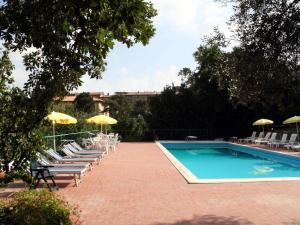 PacianoにあるHoliday Home in Paciano with Swimming Pool Terrace Billiardsのラウンジチェアとパラソル付きのスイミングプールが隣接しています。