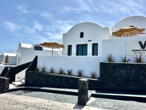 una villa bianca con alcune piante di fronte di Venus Sunrise Suites & Villas a Vourvoúlos