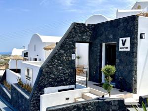una villa con facciata in bianco e nero di Venus Sunrise Suites & Villas a Vourvoúlos