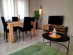 uma sala de estar com uma mesa com cadeiras e uma televisão em TRAVELLERS HOUSE em Volos