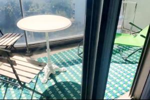 ein weißer Tisch und Stühle auf einem Balkon in der Unterkunft Studio meublé vue tour Eiffel et tout Paris in Saint-Maurice