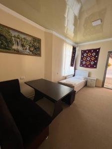 Pokój z biurkiem i łóżkiem w pokoju w obiekcie KHAN APARTMENTS w Samarkandzie