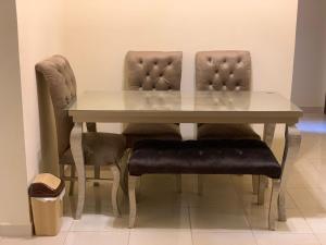mesa de comedor con 2 sillas y mesa blanca en Quiet and comfortable place in Madinaty new cairo en Madinaty